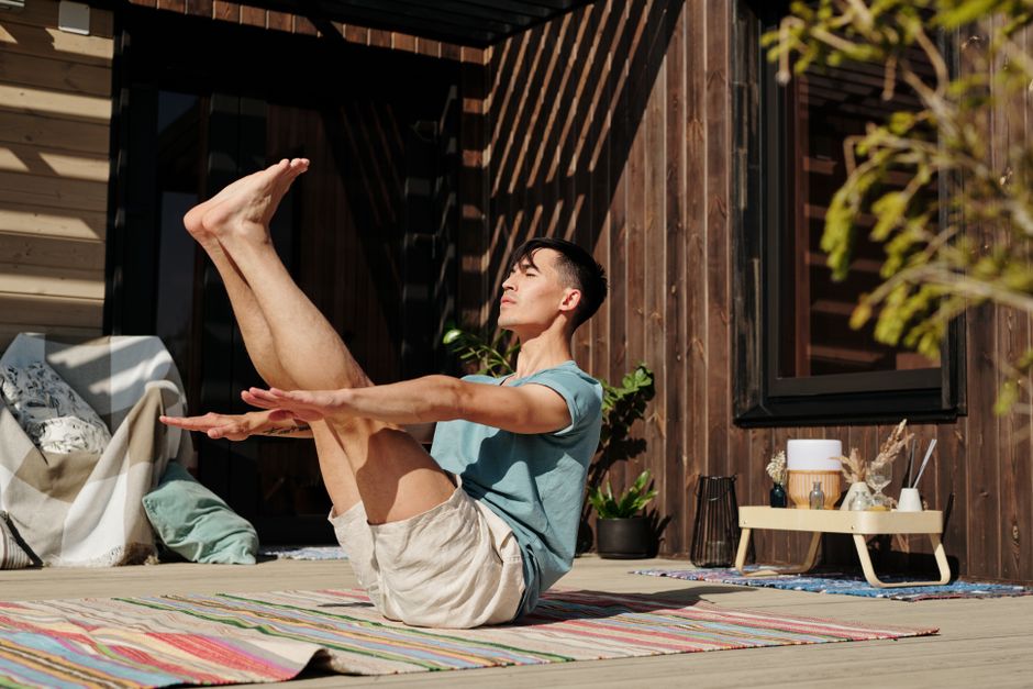 Man practicing yoga outdoors on a sunny day, showcasing balance and flexibility.