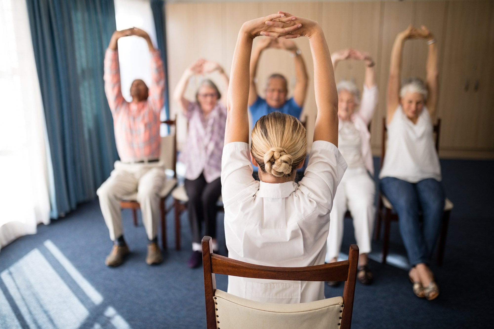 Chair yoga class raising arms overhead