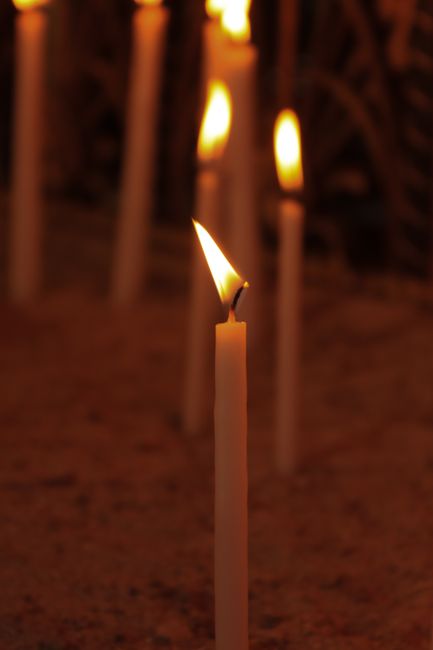Soft glowing candles in the dark create a serene, warm atmosphere.