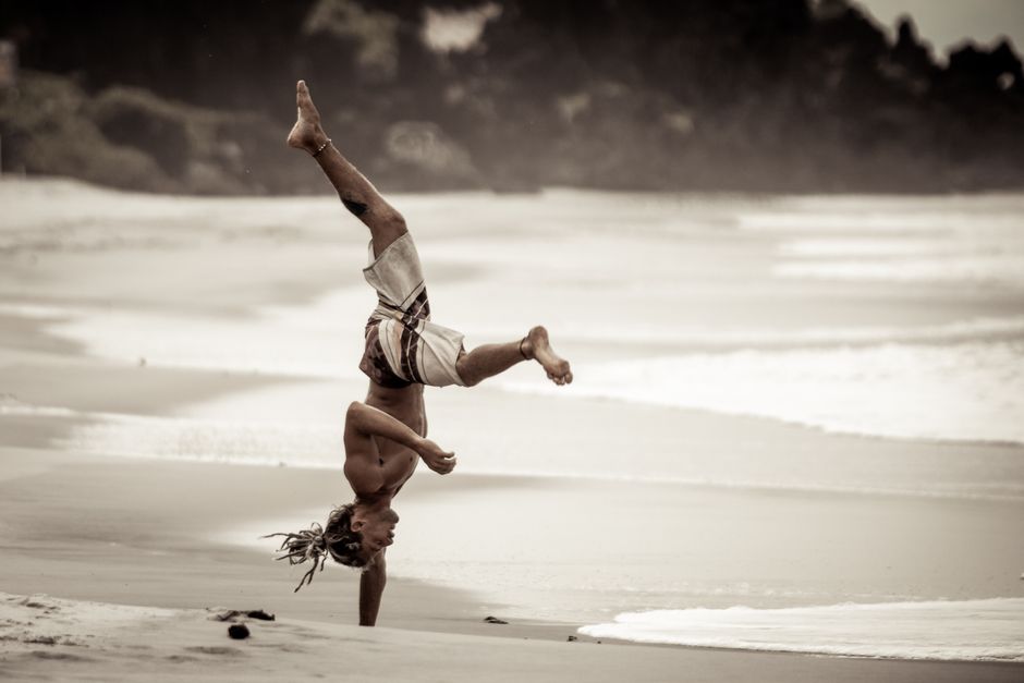 Man performing a handstand on Pipa Beach, Brazil. Capturing balance and energy.