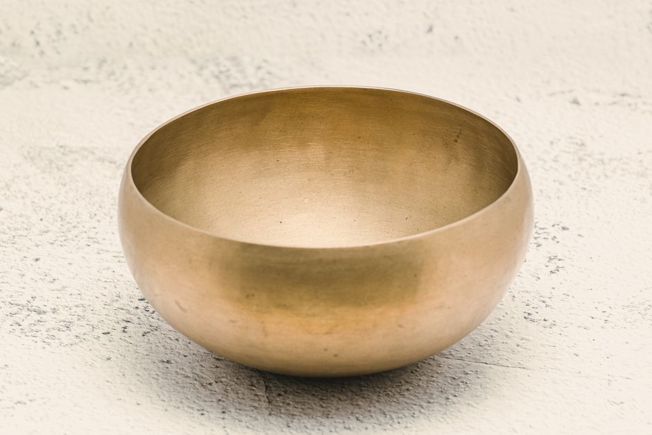 A detailed close-up of a traditional Tibetan singing bowl used in meditation and sound therapy.