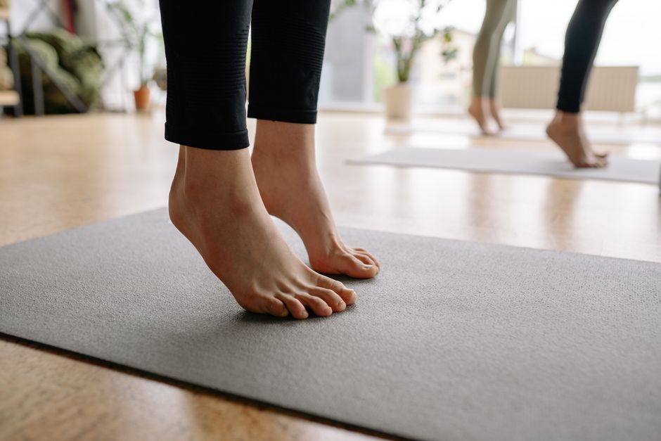Close-up of bare feet during a yoga session indoors, focusing on mindfulness.