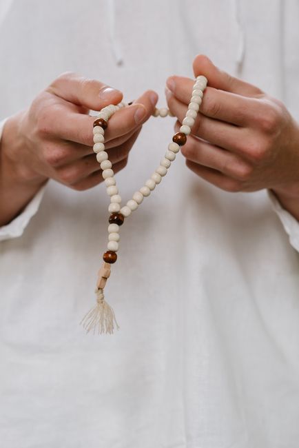 A serene close-up of hands gracefully holding prayer beads, symbolizing spirituality and meditation.