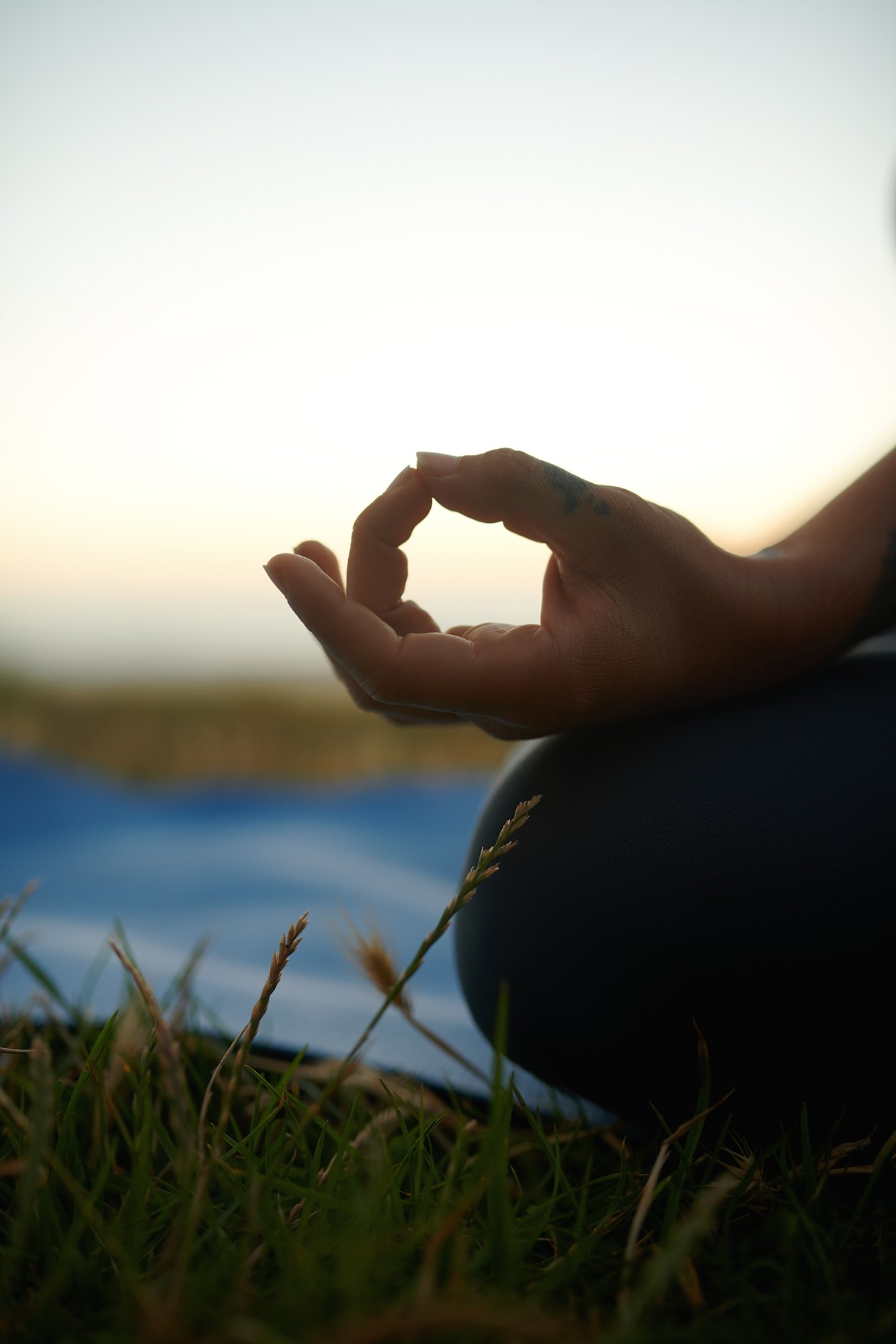 Hand in chin mudra during seated meditation by the water