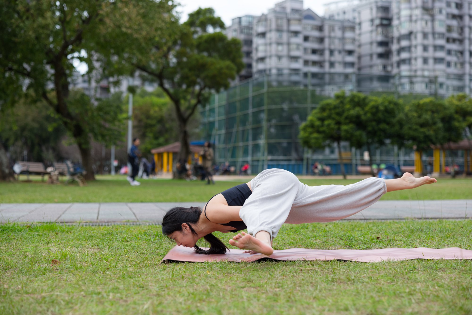 Sage Koundinya arm balance in a city park