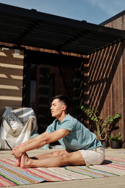 Man practicing yoga on porch, enjoying a peaceful outdoor routine in the sunshine.