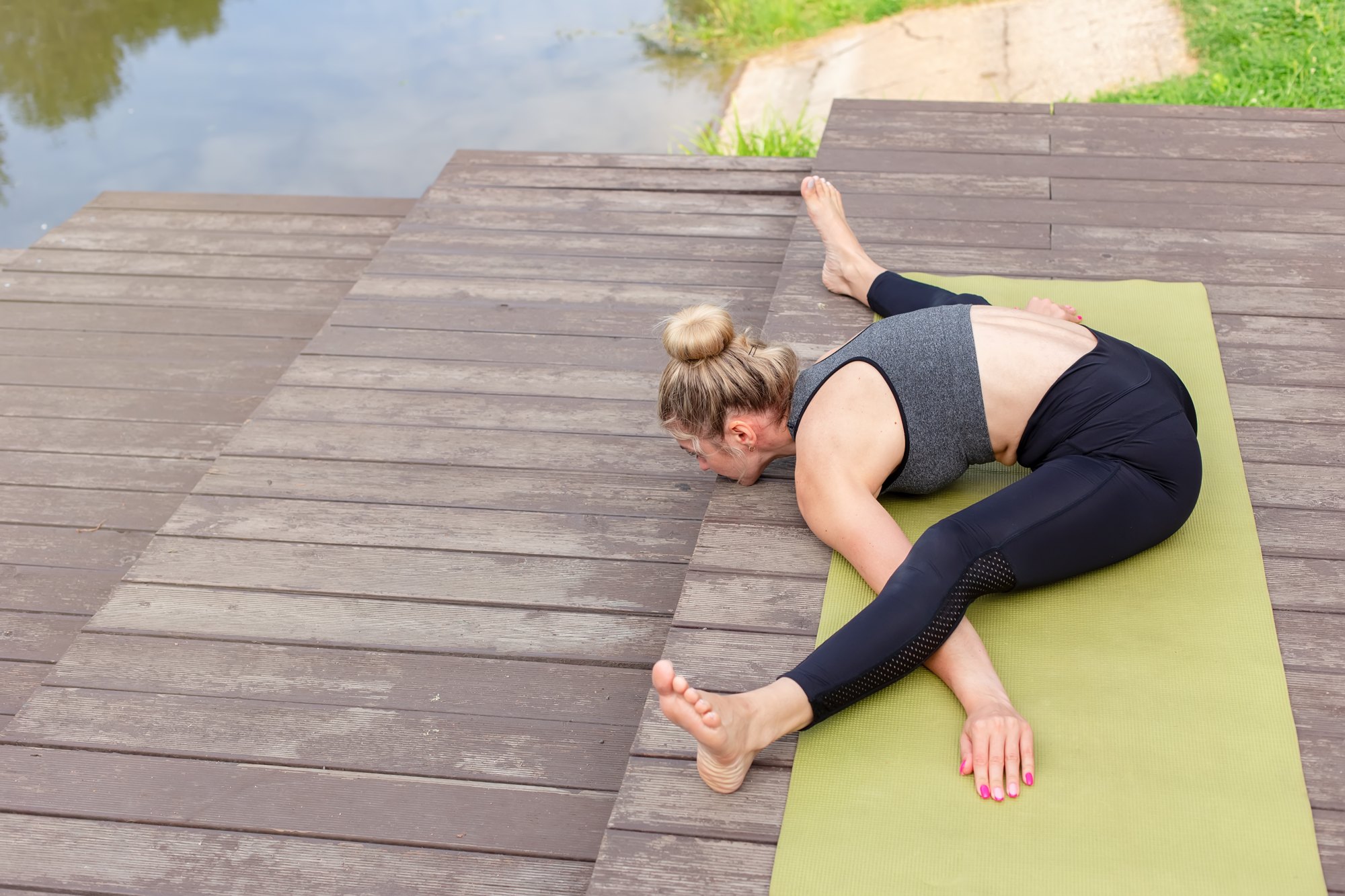 Three-limbed forward bend on a waterside deck
