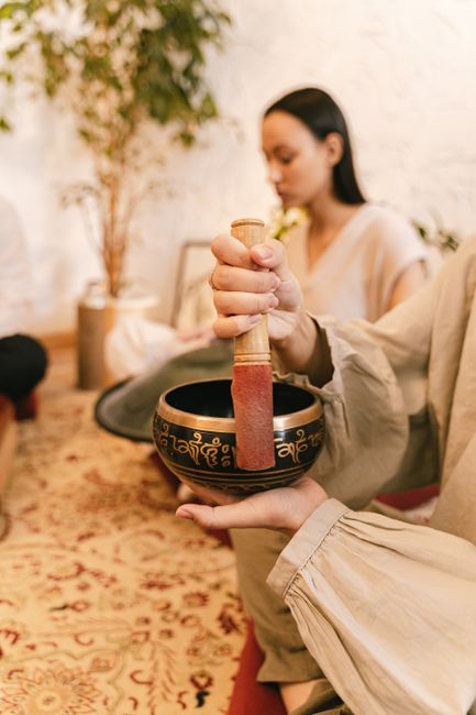 A calming scene of a Tibetan singing bowl used during a meditation session indoors.