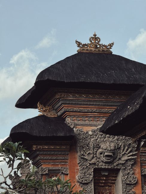 Intricate traditional Balinese temple architecture featuring ornate carvings and thatched roofs.