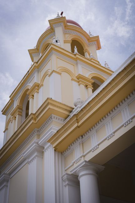 Elegant colonial church tower under a cloudy sky in Santo Domingo, Heredia, Costa Rica.